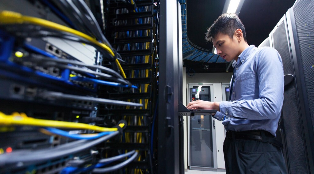A technician works on keyboard in a data center