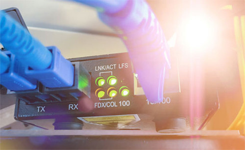 A standalone fiber-to-copper media converter device with an Ethernet port and an optical SFP slot, showing how legacy copper networks are bridged with high-speed fiber backbones.