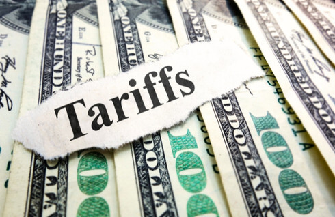 A stack of $100 bills with the word "tariff" written across them